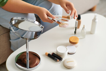 A young curly plus size woman explores her beauty routine by trying out various cosmetic products...