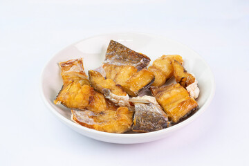 Crispy fried barracuda slice on white dish. Barracuda Fish Cooking. Dried Barracuda fish fillet.