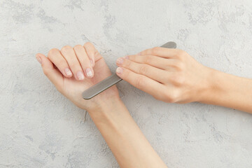 Woman filing damaged nails. Fingernails with onycholysis after removing gel polish