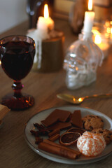 Books, lit candles, red wine, snacks and various deocration on the table. Dark academia or Halloween concept. Selective focus.