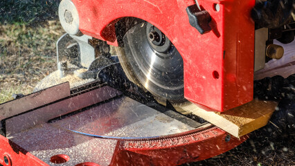 A close-up shot of a circular saw cutting timber in a garden