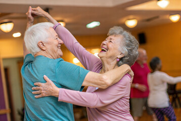 Joyful Elderly Couple Dancing Together at a Community Center Event