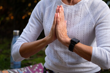 Women's hands folded in front of the chest in anjali mudra