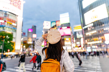 Young woman traveler walking at Shibuya Crossing the popular pedestrian scramble crossing in Shibuya, Tokyo