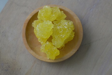 close up of yellow rock sugar on a wooden plate