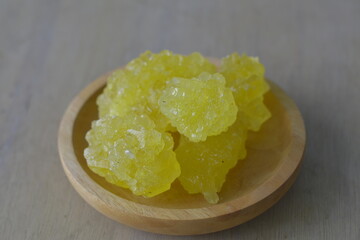 close up of yellow rock sugar on a wooden plate