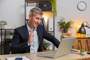 Caucasian young businesswoman working on laptop computer at office desk talking on online communication video call with employee, boss. Manager guy support services looking at webcam of computer.