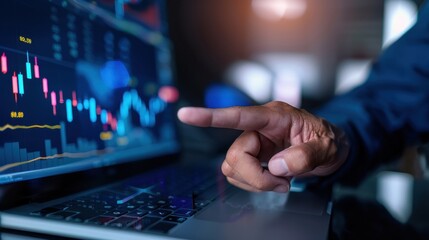 Fototapeta premium Investor analyzing stock market data on laptop with candlestick charts and financial graphs