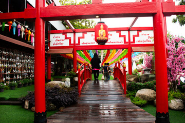 Ancient torii gate traditional japanese for thai people traveler walking crossing bridge to travel visit respect praying antique buddha at Wat Prasat temple on October 18, 2024 in Nonthaburi, Thailand