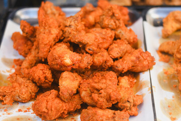 Close-up of crispy fried chicken in a stainless steel tray.