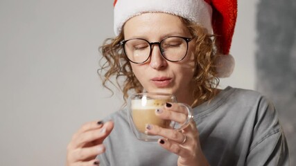 Christmas time woman in santa hat enjoying hot coffee drink, inspired by upcoming holiday vacation. Joyful festive atmosphere concept, time for yourself. Close-up shot - Powered by Adobe