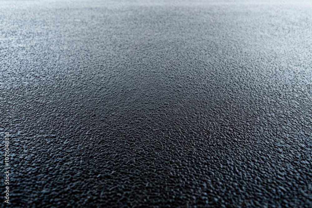 Poster close-up of textured black surface, featuring a matte finish that adds depth and intrigue, ideal for