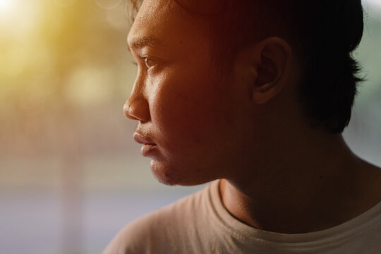 Side profile of Southeast Asian man looking at the distance with bokeh background. Close up shot.