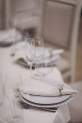 on the festive banquet table are plates with napkins, glasses and cutlery. festive table with empty plates and glasses at restaurant