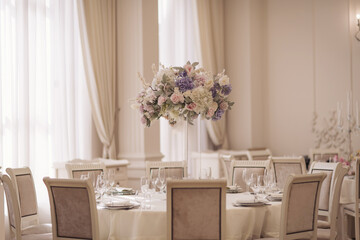 festive wedding decoration. Beautiful fresh flowers in glass vase on dining table on wedding day. luxury wedding decor with flowers and glass vases with jewels on round tables. expensive catering.