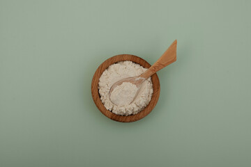 Guar gum powder or guaran in wooden bowl with spoon, top view. Food additive E412, Thickening agent, Binder, Excessive Water absorber. Guar Gum used in cosmetics and food industry