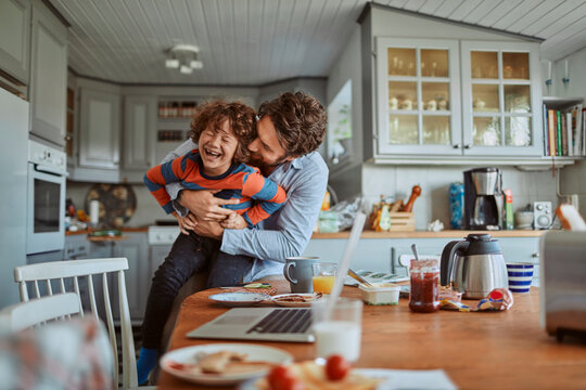 Father and son having fun at kitchen table