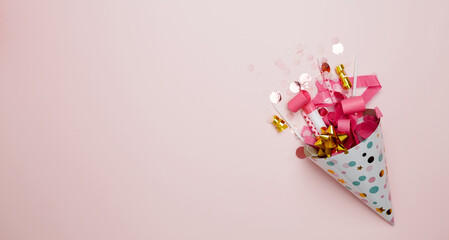 Concept of festive birthday celebrations. Party hat for birthday with colorful balloons, party hats, candles confetti