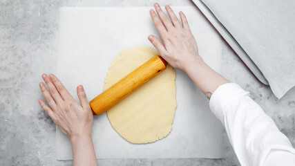 Woman rolling out dough. Making different shapes of fall cookies for Halloween