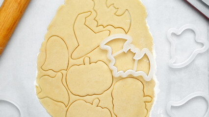 Making different shapes of fall cookies for Halloween. Dough with cookie cutter