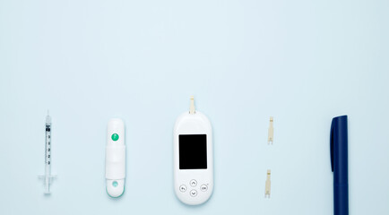 Concept of worldwide diabetes awareness. Diabetes concept with syringe pen with insulin, glucometer, blood test strips