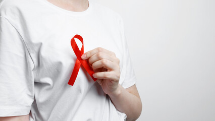 World AIDS Day. Woman holding red AIDS awareness ribbon