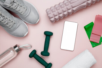 Healthy lifestyle, sport equipment, dumbbells, foam roller for Myofascial release and smartphone for viewing home workouts
