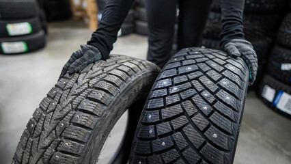 Mechanic keeps new summer and winter car tires in the garage. Comparison of wheels for different...