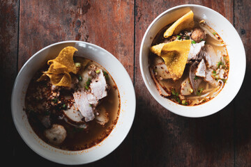 Two bowl of noodles with pork served with crispy wontons. Season the food with the seasoning, Thai food delicious
