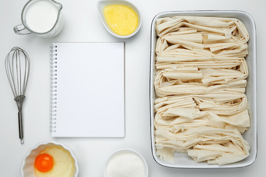 Cooking ingredients and notebook on a white background. For baking Crinkle Cake. Mockup design for recipe or food blog