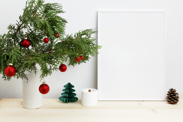 White frame for mockup with thuja branches in a vase decorated with Christmas ornaments