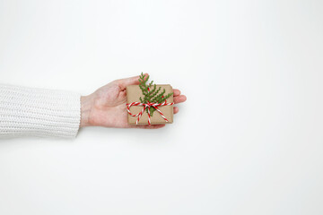 Woman’s hand holding a wrapped gift, symbolizing celebration, giving, and thoughtful gesture