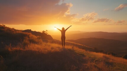 A person joyfully embracing the sunset while standing atop a hill with expansive views of the landscape at dusk