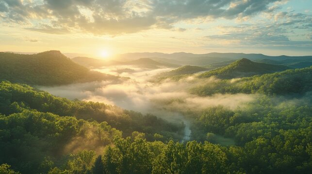 Breathtaking view of the Ozark Mountains at sunrise with mist filling the valleys and sunlight breaking through the clouds