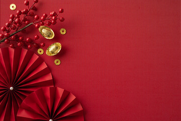 This image showcases traditional Chinese New Year decorations with red fans, gold ingots, and red...