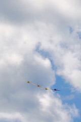 Propeller plane in formation flight in the sky among the clouds