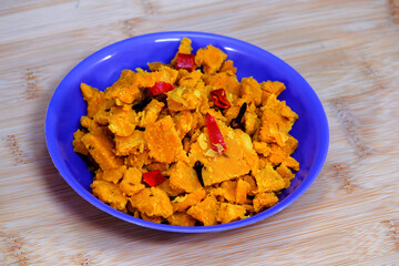 The side view of Gujarati Kathiyawadi Spicy Dhokali pieces Sabji emphasizes the unique characteristics of the blue dish