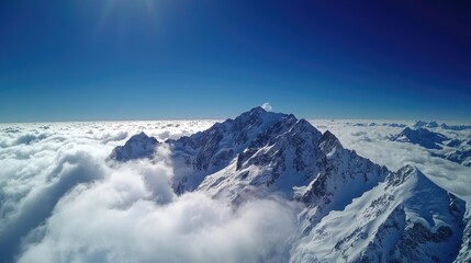 Fototapeta premium Majestic mountain peak rising above cloudy sky, showcasing breathtaking natural beauty.