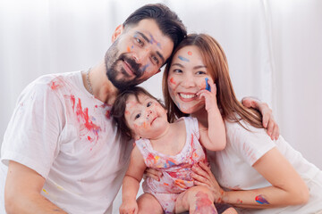 Multicultural parent with little toddler having fun laugh playing spending free time painting faces in holiday love bonding, Have fun and take photos together, learning skills of preschool children.