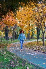 Obraz premium Redhead woman walking in the park in the autumn