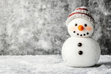 Obraz premium A cheerful snowman with a hat and buttons, set against a snowy background.
