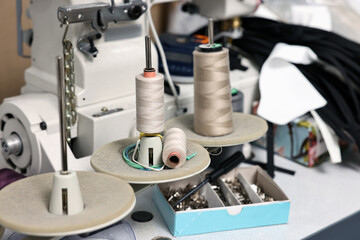 Sewing machine with spools of thread in professional workshop, closeup