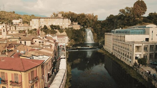 Drone in of the waterfall of Isola Liri: Approaching the waterfall of Isola del Liri crossing the town and the its fluvial park