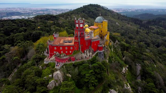  Famous National Palace of Pena situated in Sintra, Portugal. The castle stands on the top of a hill in the Sintra Mountains. Drone circling around the castle.