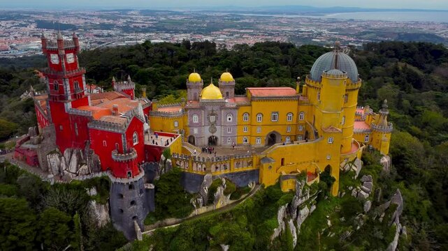 Famous National Palace of Pena situated in Sintra, Portugal. Drone going backward. The castle stands on the top of a hill in the Sintra Mountains above the town.