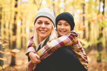 Joyful mother and his little boy. mother and child have fun on nature outdoors at autumn park.