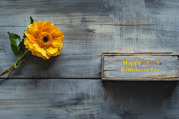 Happy Birthday to You, text in yellow and green colors, with lily flowers on a grey wooden background