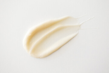 Beige creamy texture moisturizer sample on white background. Minimalist skin care beauty product