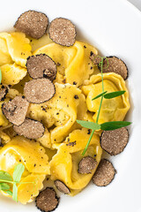 Black truffle ravioli. Italian autumn and winter recipes. Autumn gourmet cuisine of Piedmont, Northern Italy, France, Spain, close up