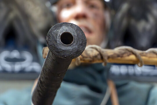 A medieval soldier aims a firearm forward, 15th century